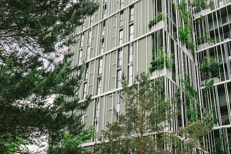 A high-rise building with trees in the foreground