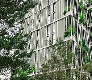 A high-rise building with trees in the foreground