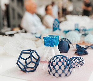 Shapes from the 3D printer, different shades of blue on a white surface