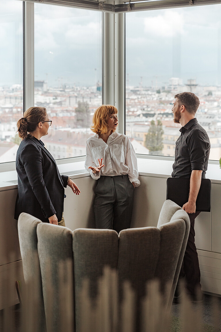 Three people talking while standing