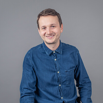 Male person, smiling, dark shirt, dark short hair