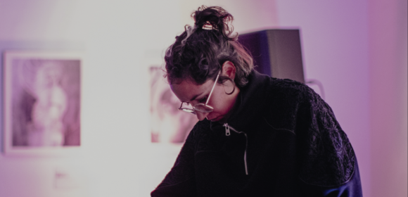 Photo of woman leaning down towards mixing desk