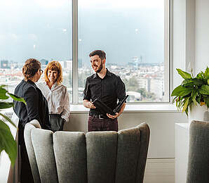 Three people talking while standing_landscape format