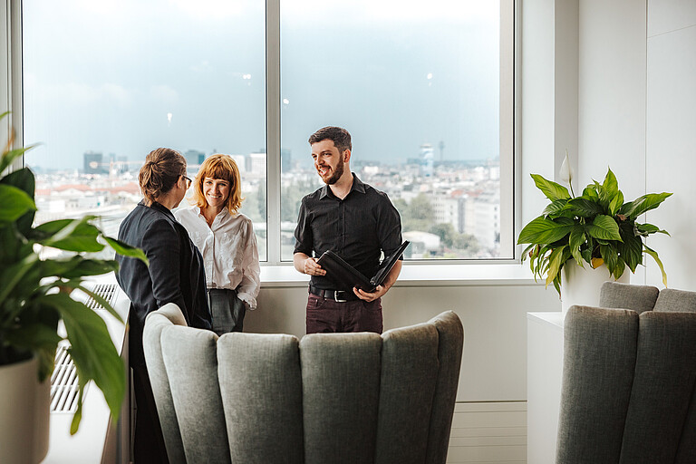 Three people talking while standing_landscape format