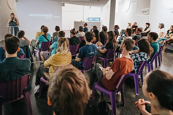 Subotron arcademy Woman gives talk in front of audience