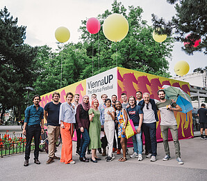 Crowd in front of a container with the ViennaUP logo and balloons on Karlsplatz in Vienna.