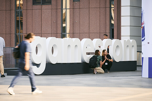 Gamescom sign with visitors