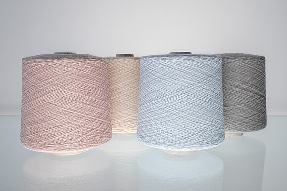 Spools of yarn dyed with the Vienna Colours, in pastel shades of pink and blue.