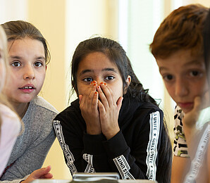Three children with concentrated expressions