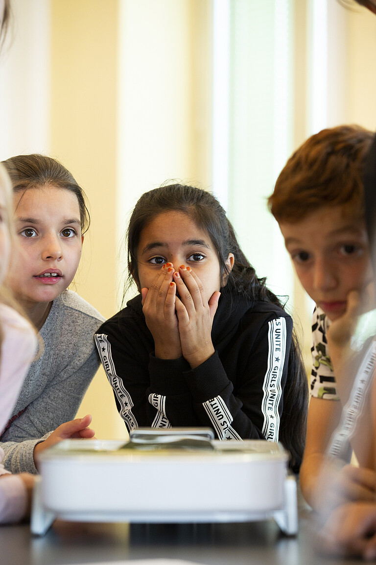 Three children with concentrated expressions