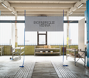 Biofabrique Vienna logo displayed on a hanging banner in the Nordwestbahnhof hall