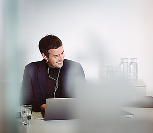 Man sitting in front of laptop with headphones on