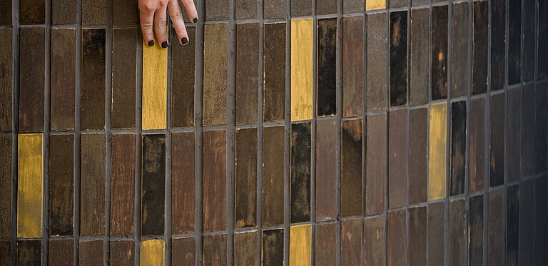 Close up of bar, focus on tiles which have been developed at Biofabrique Vienna hand touches surface