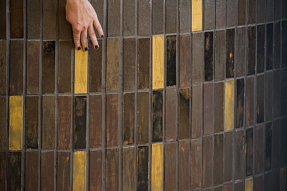 Close up of bar, focus on tiles which have been developed at Biofabrique Vienna hand touches surface