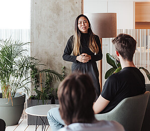 Woman as lecturer in front of small group