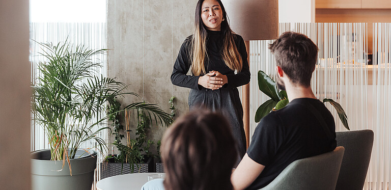 Woman as lecturer in front of small group