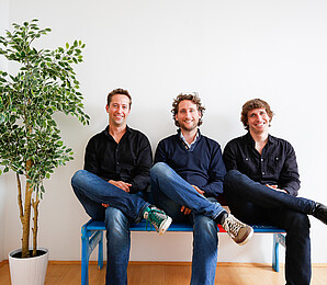 TourRadar: Drei Männer sitzen auf einer Bank. 