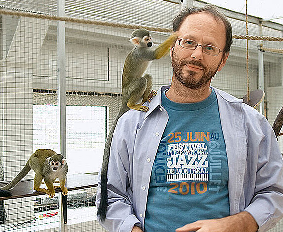 [Translate to English:] EIn Mann im weißen Kittel kümmert sich liebevoll um zwei Äffchen