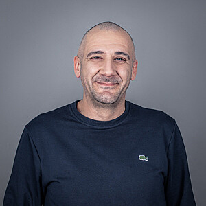 Portrait von Mario Kamenko, ein Mann im dunkelblauen Pullover