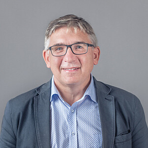Portrait von Peter Kuen, ein Mann mit Brille