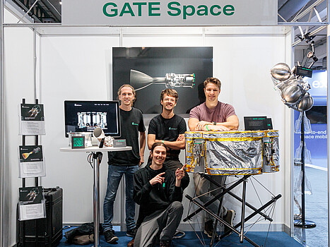 Gate Space: Personen stehen vor einem Messestand des Unternehmens Gate Space
