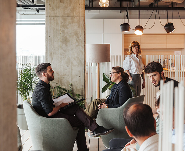 Eine Gruppe Menschen im Gespräch in einem Coworking-Space